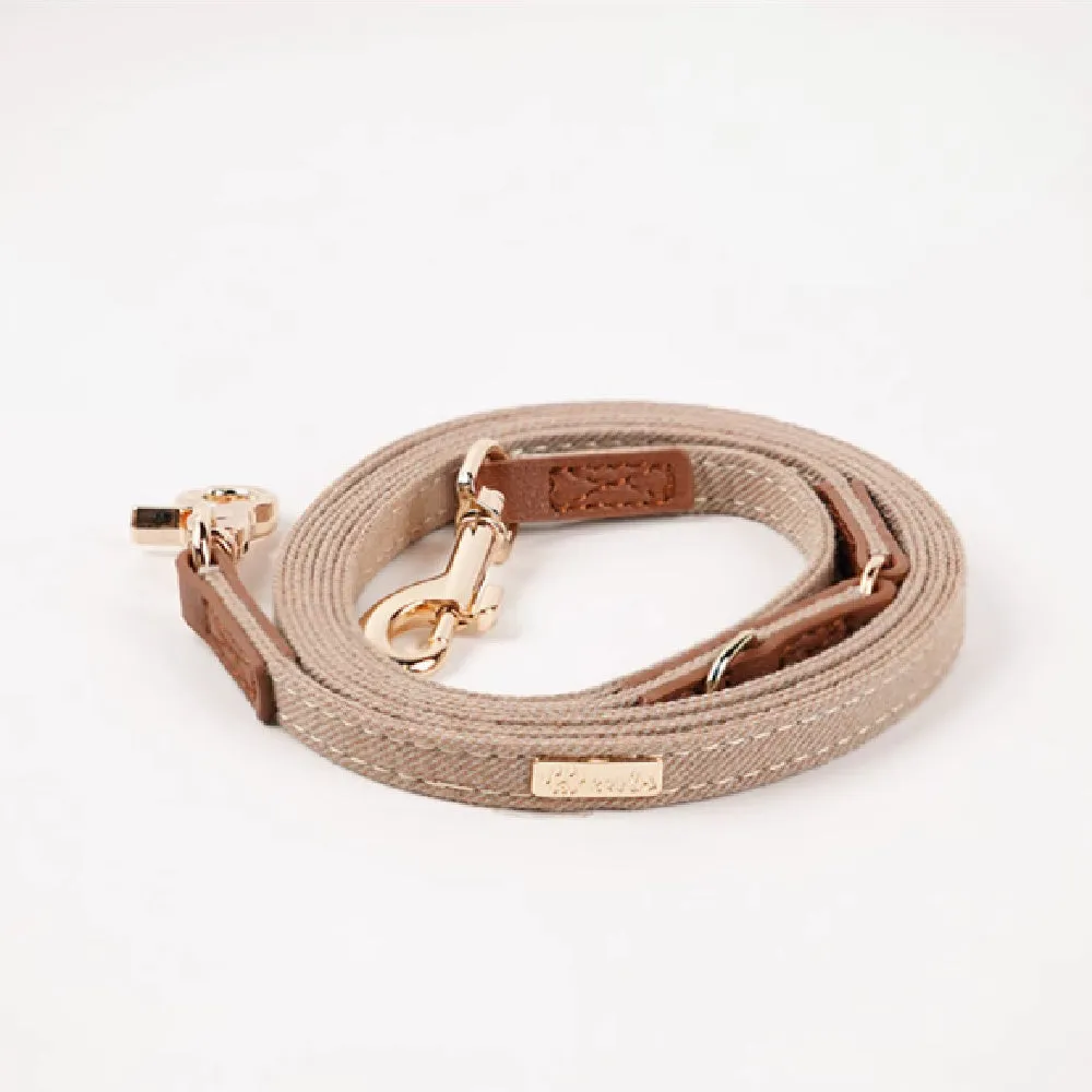 Adjustable mohair dog collar with nameplate and hand holding rope in cement gray