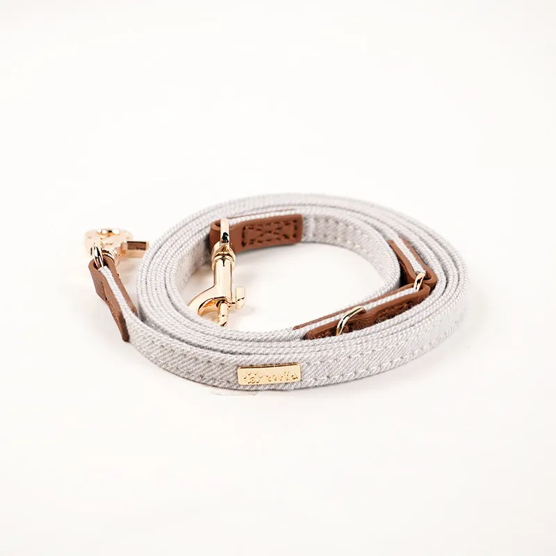Adjustable mohair dog collar with nameplate and hand holding rope in cement gray