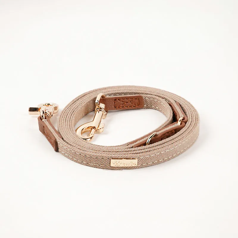 Adjustable mohair dog collar with nameplate and hand holding rope in cement gray