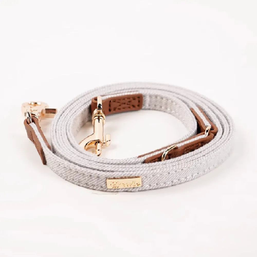 Adjustable mohair dog collar with nameplate and hand holding rope in cement gray