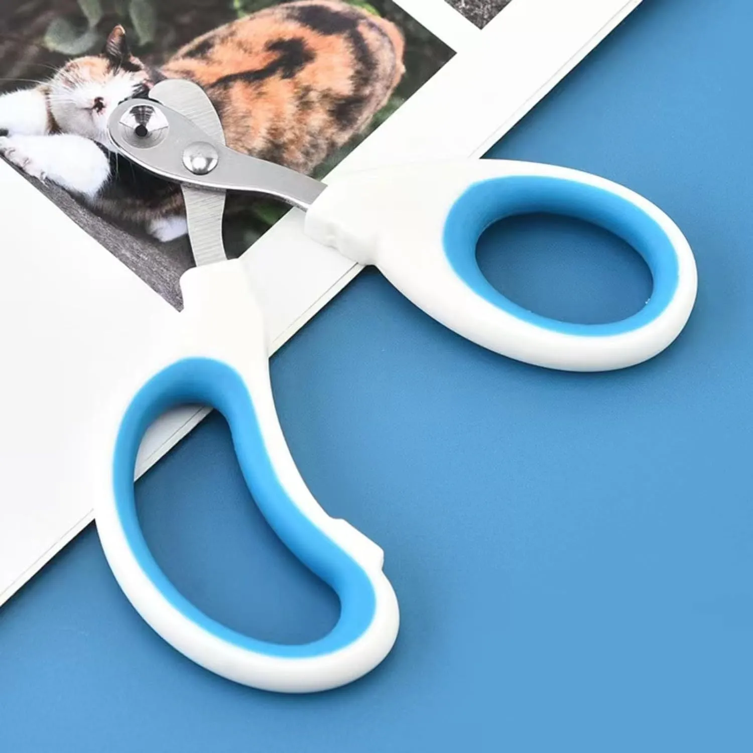 Blue handled pet nail clippers showing circular cut hole with 2mm fixed aperture and stainless steel blade.