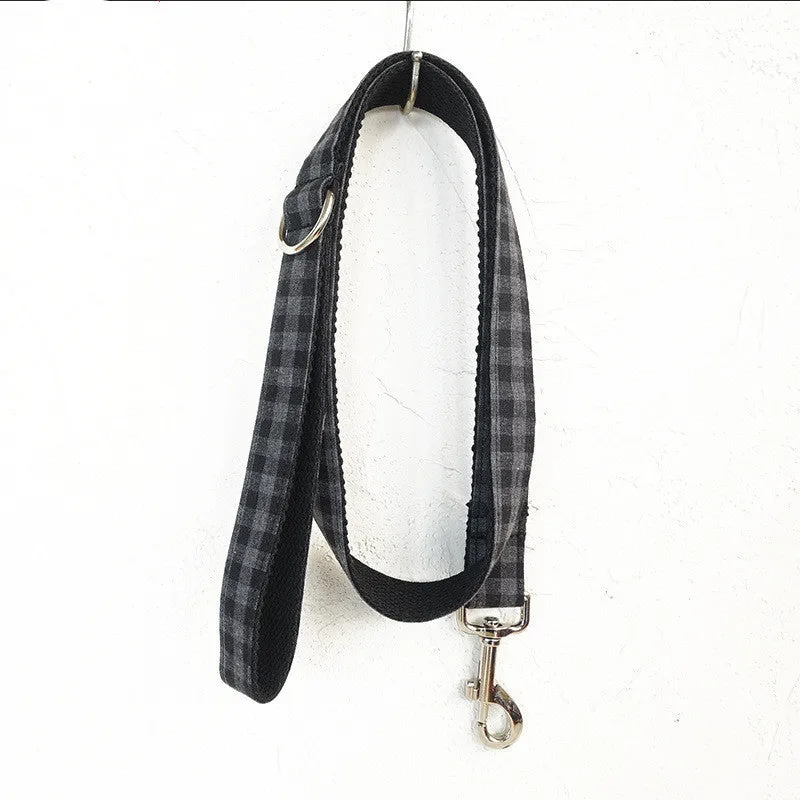 Black polyester dog training leash with metal chain ring on a plain background