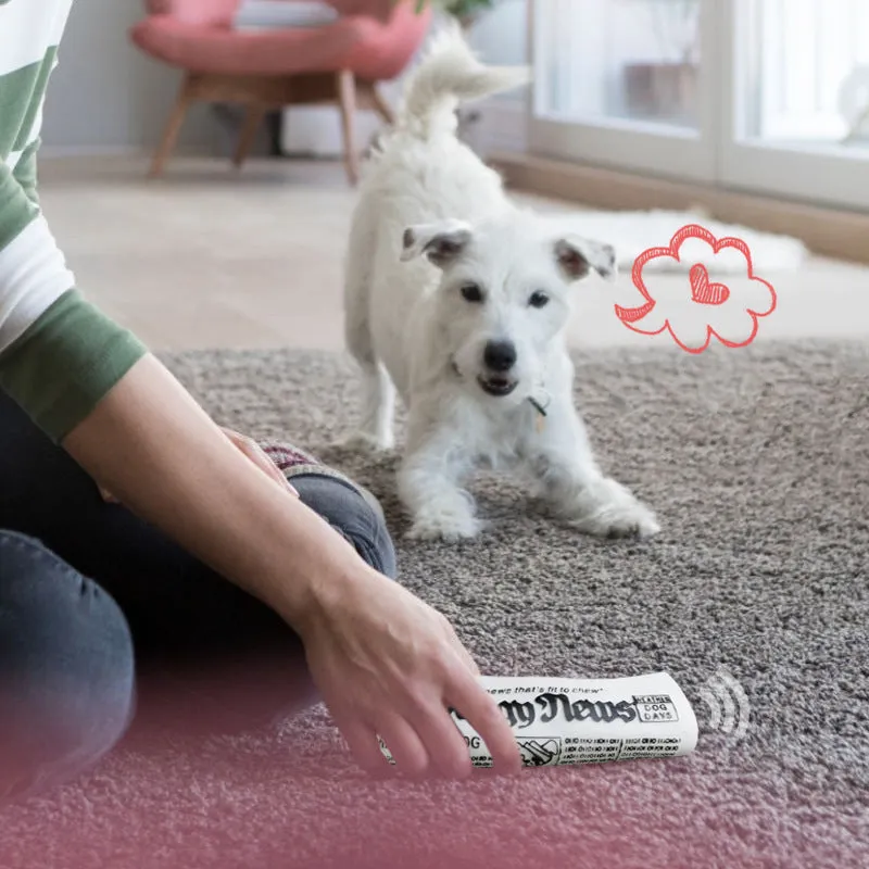 Squeaky black and white PVC dog toy shaped like a rolled newspaper on a surface