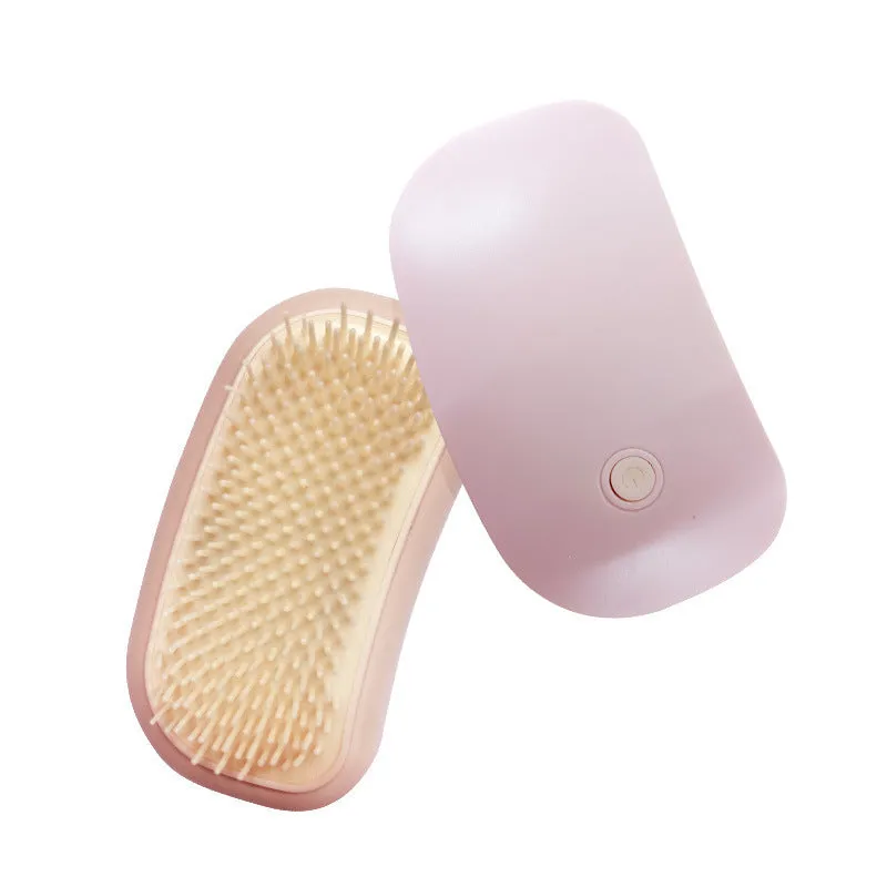 Pink handheld electric pet grooming brush with soft TPE teeth for cats and dogs.