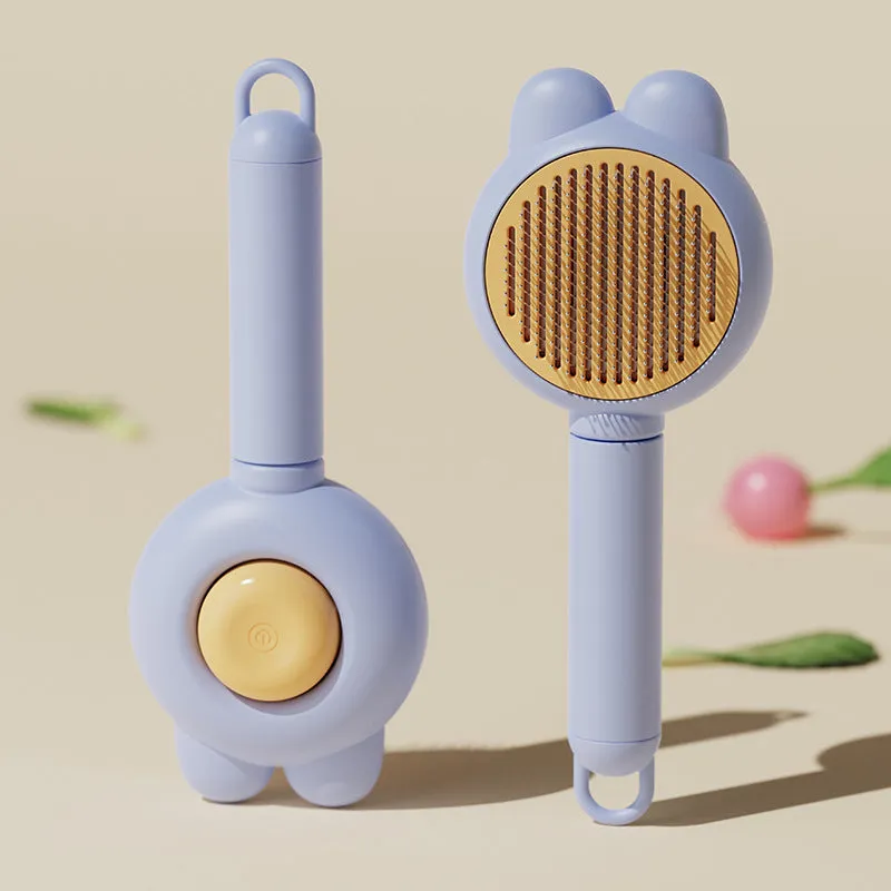 Self-cleaning pet brush with coloured comfort-grip handle and metal comb, shown with release button activated.