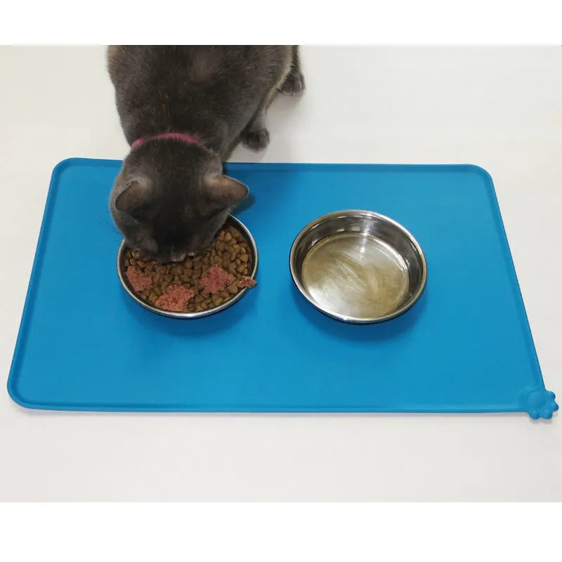 Black silicone dog food mat measuring 47 by 30 centimetres with non-slip surface and raised edges.