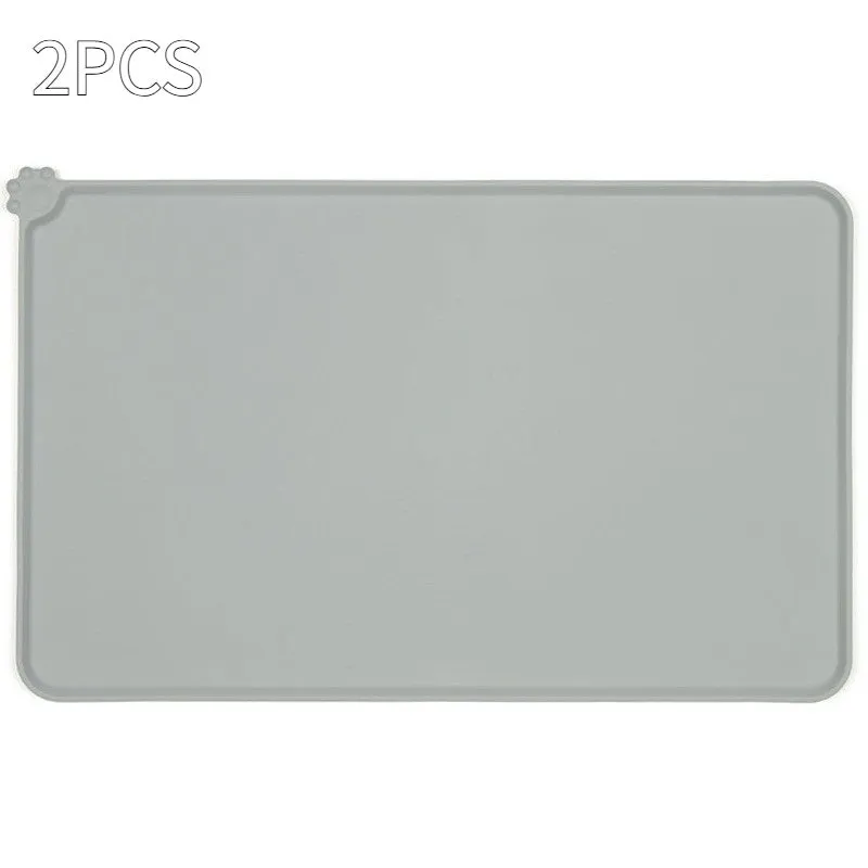 Black silicone dog food mat measuring 47 by 30 centimetres with non-slip surface and raised edges.