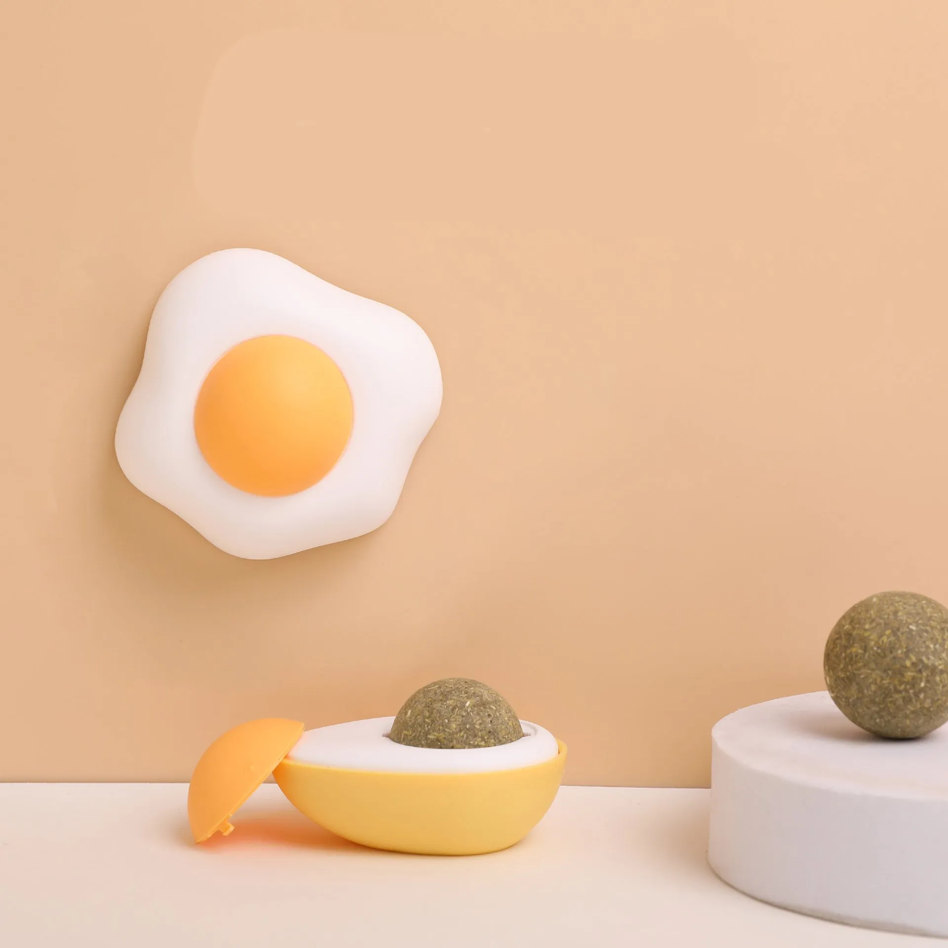 Interactive catnip ball toy with egg design mounted on wall for feline play