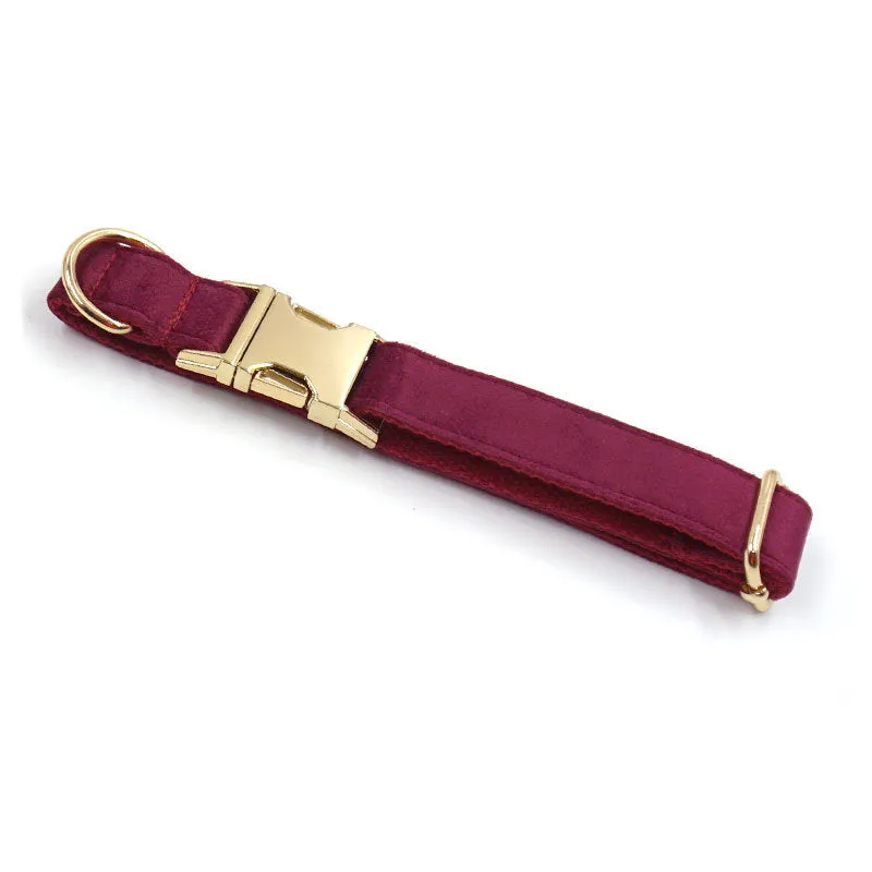 Burgundy velvet dog collar set with bow tie and leash on a wooden floor