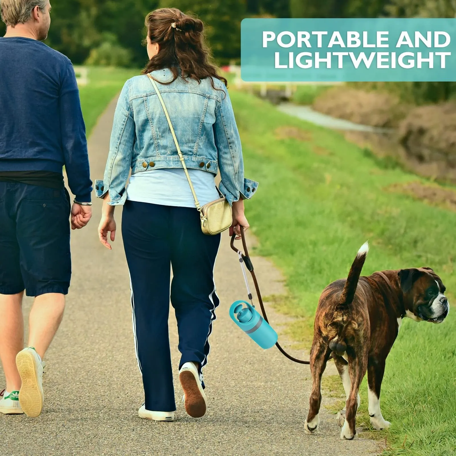 Blue portable dog poop scooper with built-in bag dispenser, clipped to a dog leash