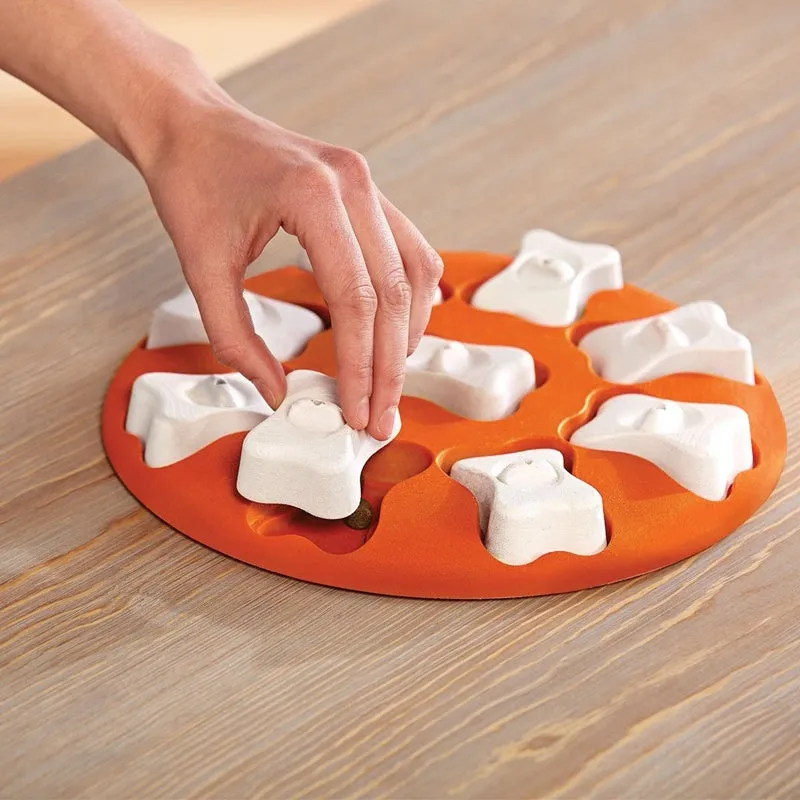 Orange and white plastic leak food toy for dogs and cats, puzzle feeder on surface