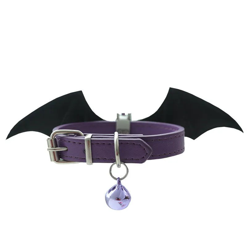 Small black patent leather choker collar with attached devil wings and a bell.