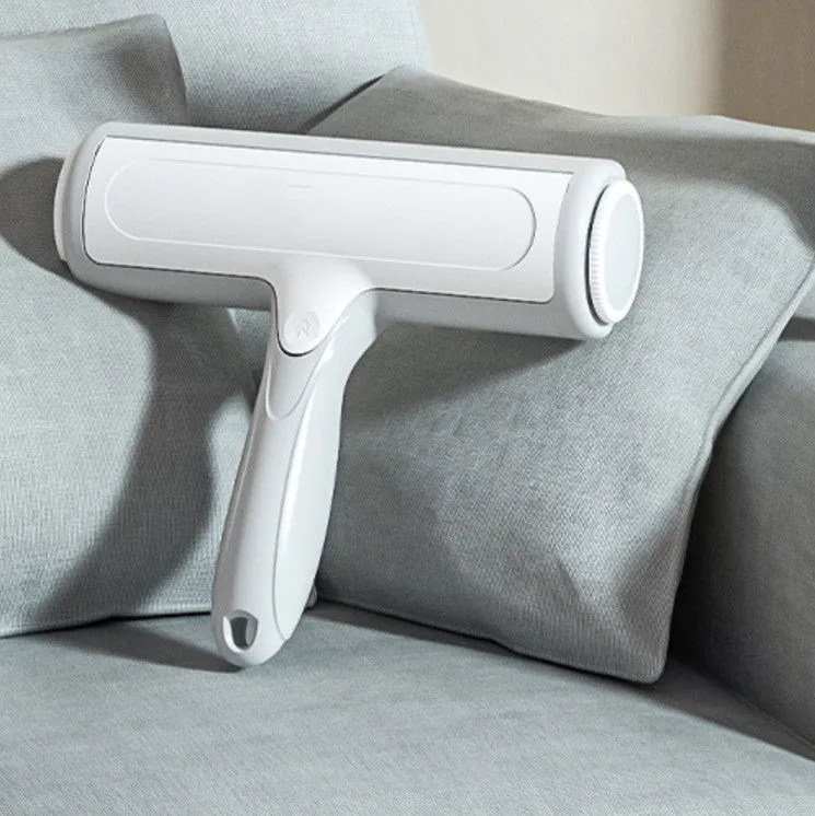 Pet hair remover roller brush with automatic cleaning, 19x18cm, in green orange, on a sofa surface.