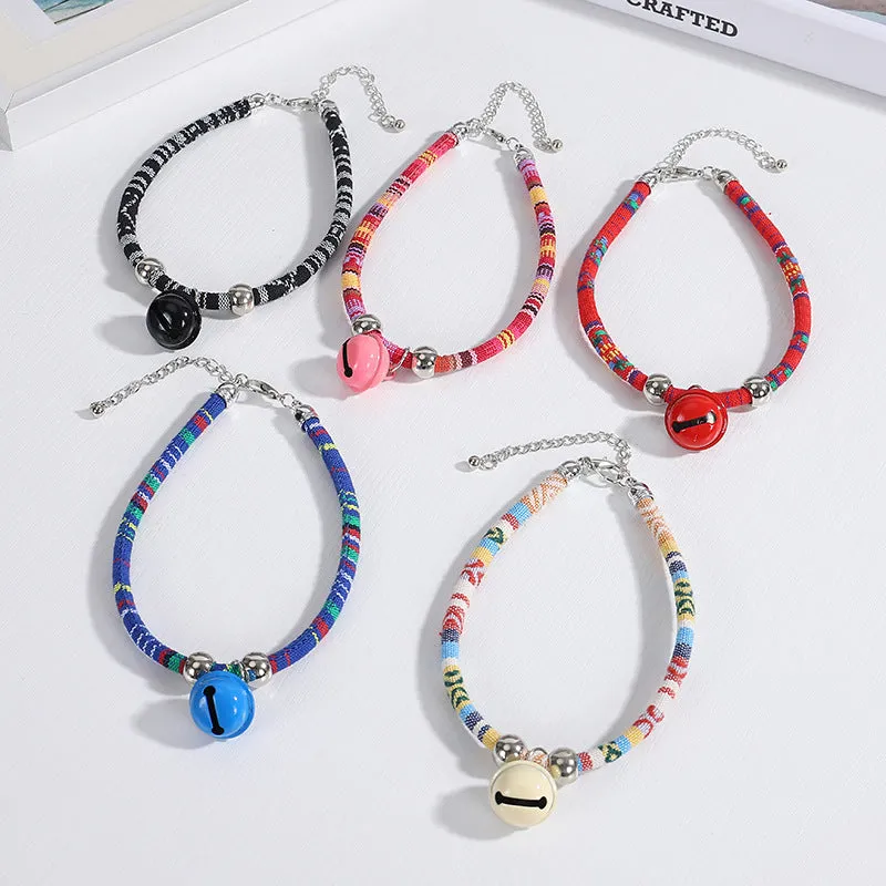 Coloured ethnic pattern adjustable pet collar with metal bell and D-ring on a nylon strap.