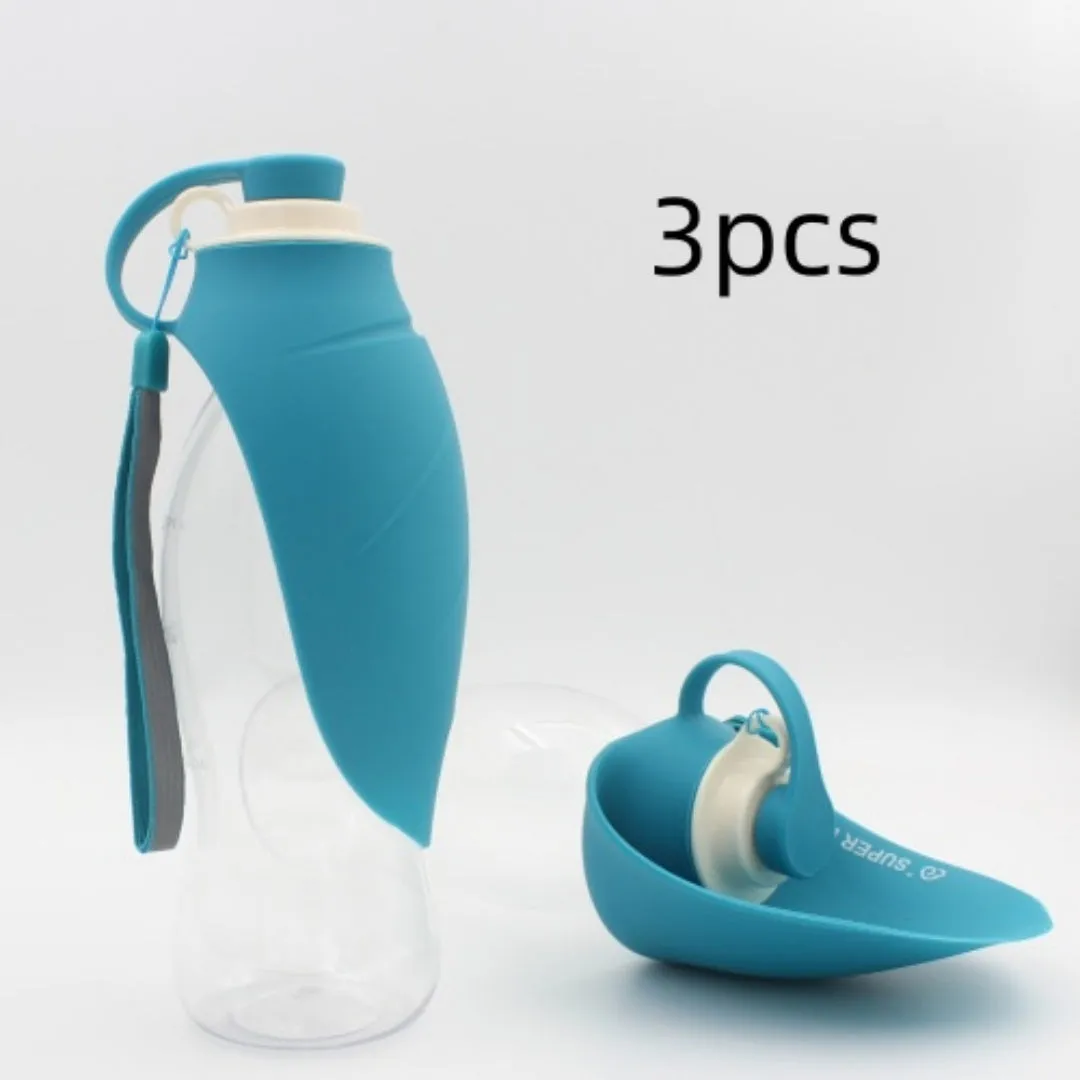 Portable pet water dispenser with black body and flip-up silicone cup next to a dog
