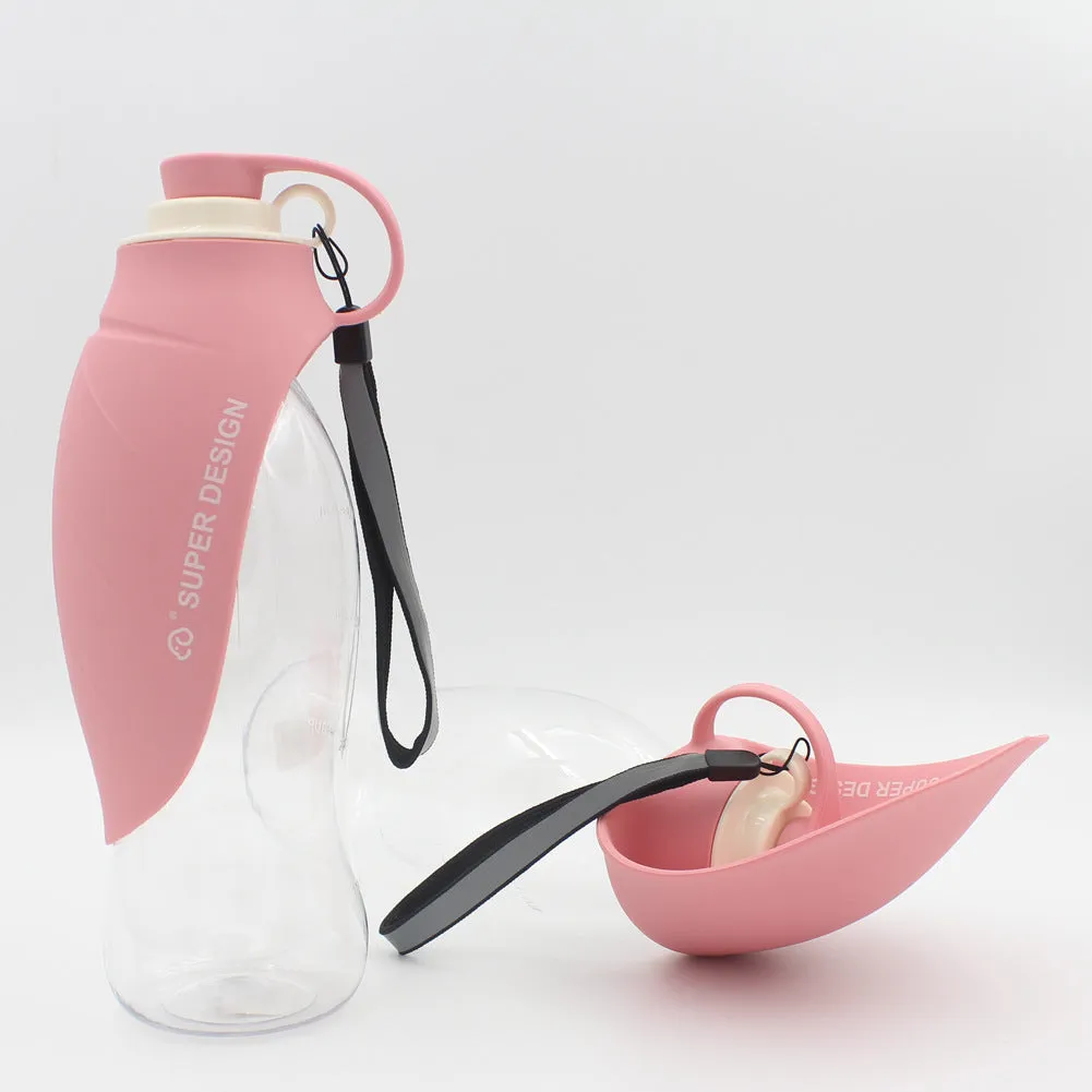 Portable pet water dispenser with black body and flip-up silicone cup next to a dog