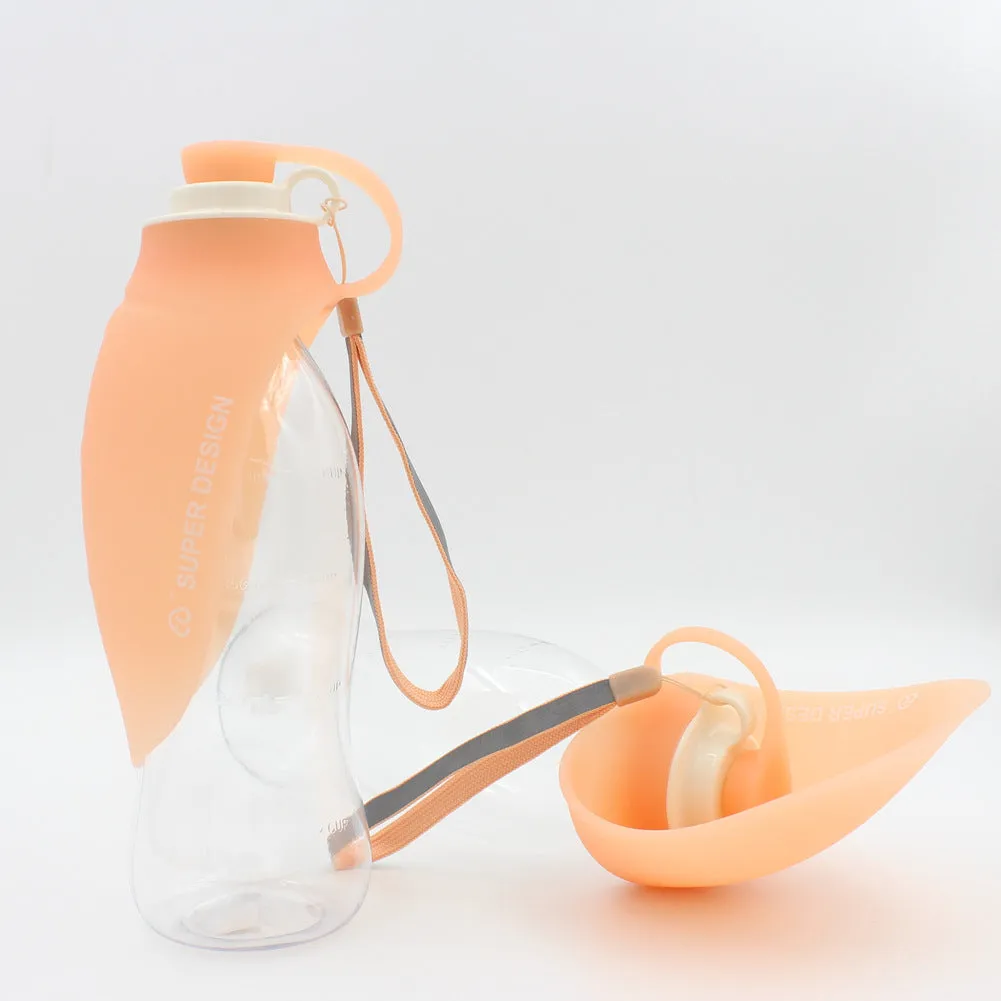 Portable pet water dispenser with black body and flip-up silicone cup next to a dog