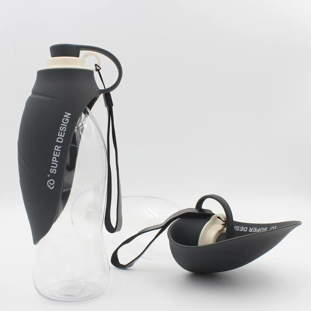 Portable pet water dispenser with black body and flip-up silicone cup next to a dog