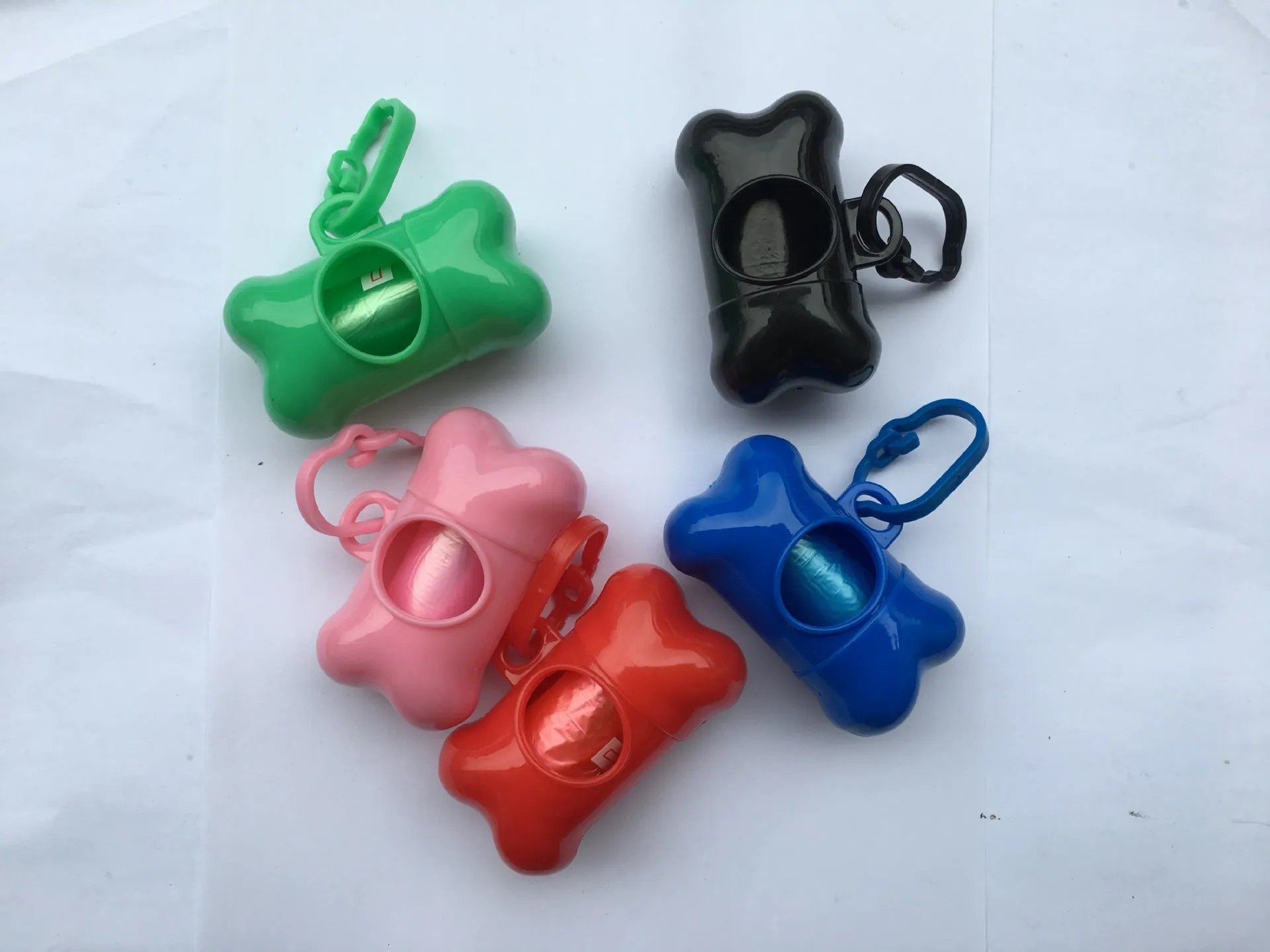 Bone-shaped pet garbage bag dispenser in new PP material, 8cm long and 5cm wide, on a table