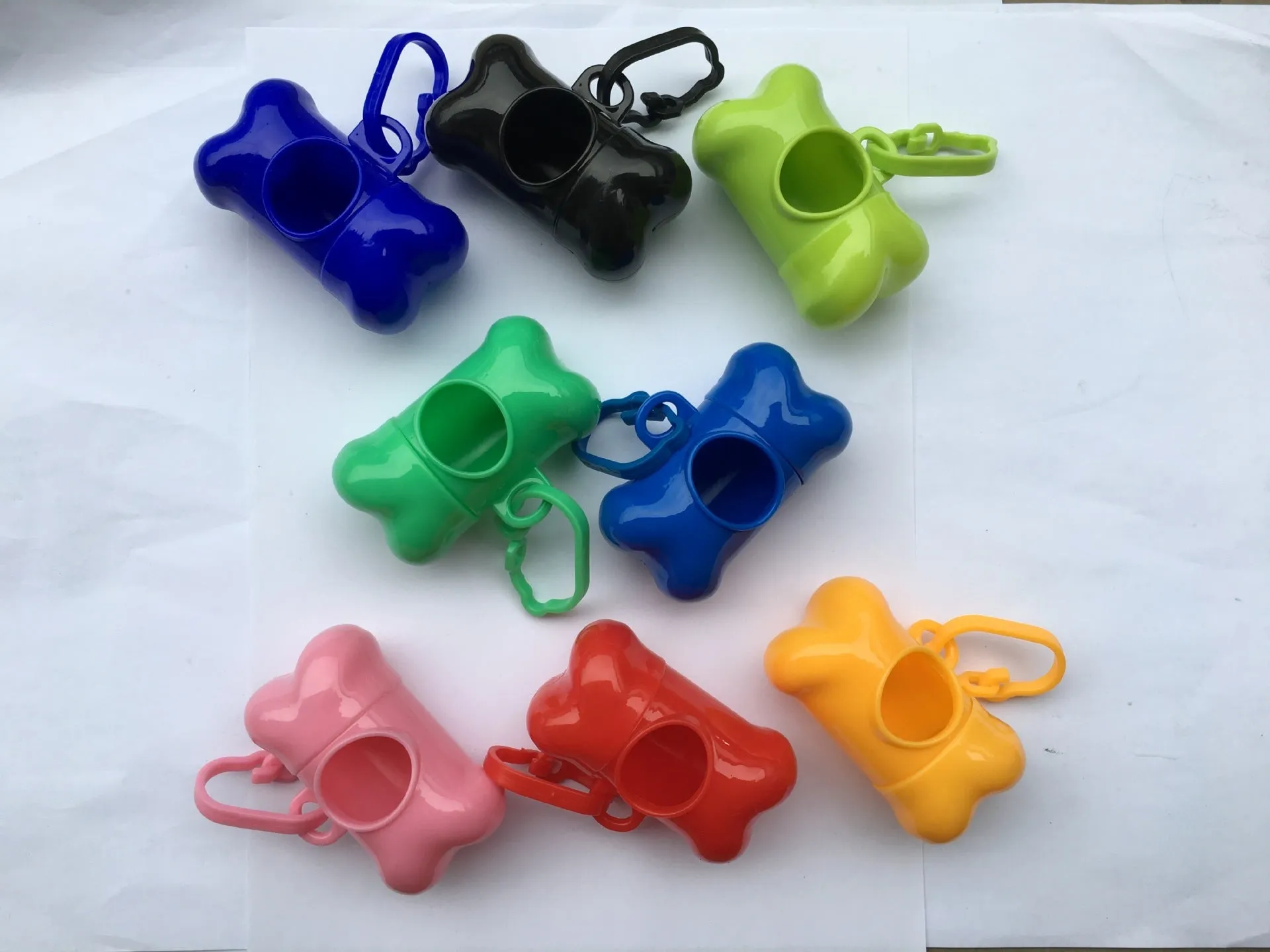Bone-shaped pet garbage bag dispenser in new PP material, 8cm long and 5cm wide, on a table