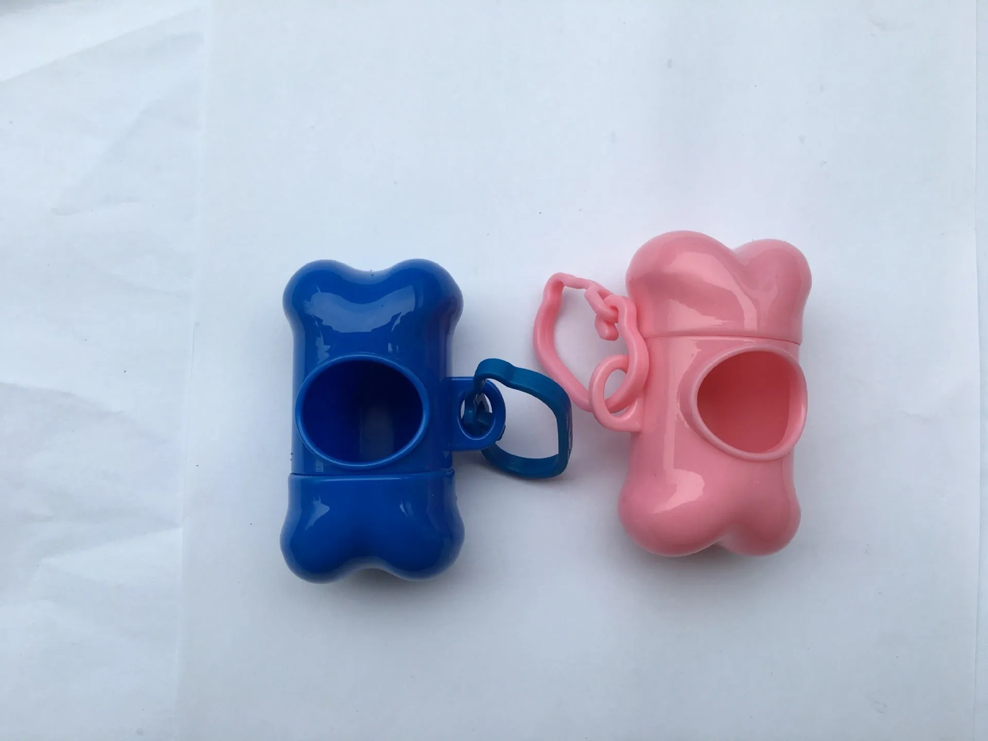Bone-shaped pet garbage bag dispenser in new PP material, 8cm long and 5cm wide, on a table