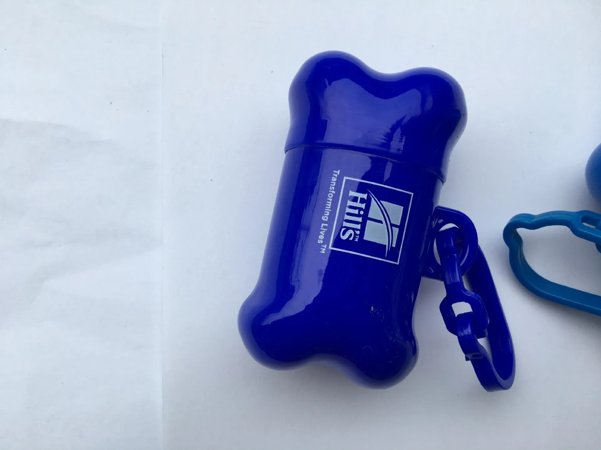 Bone-shaped pet garbage bag dispenser in new PP material, 8cm long and 5cm wide, on a table
