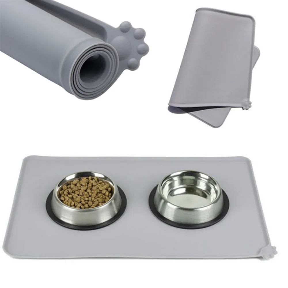 Grey waterproof silicone pet mat with raised edges and a non-slip base, measuring 47x29.5cm, placed under two pet bowls