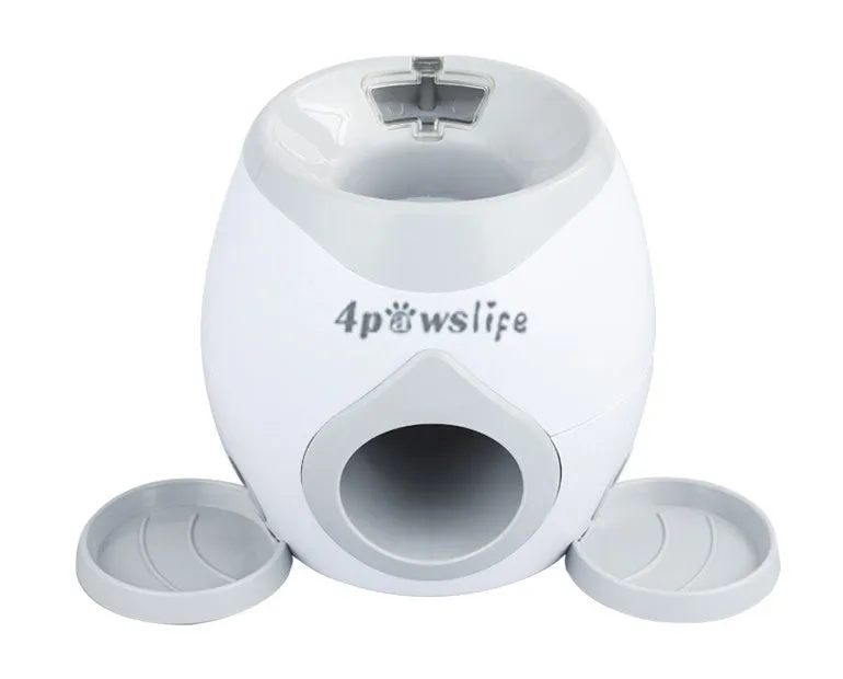 Smart pet feeder reward machine with two tennis balls and treat dispenser in green and white colour, shown on a wooden floor