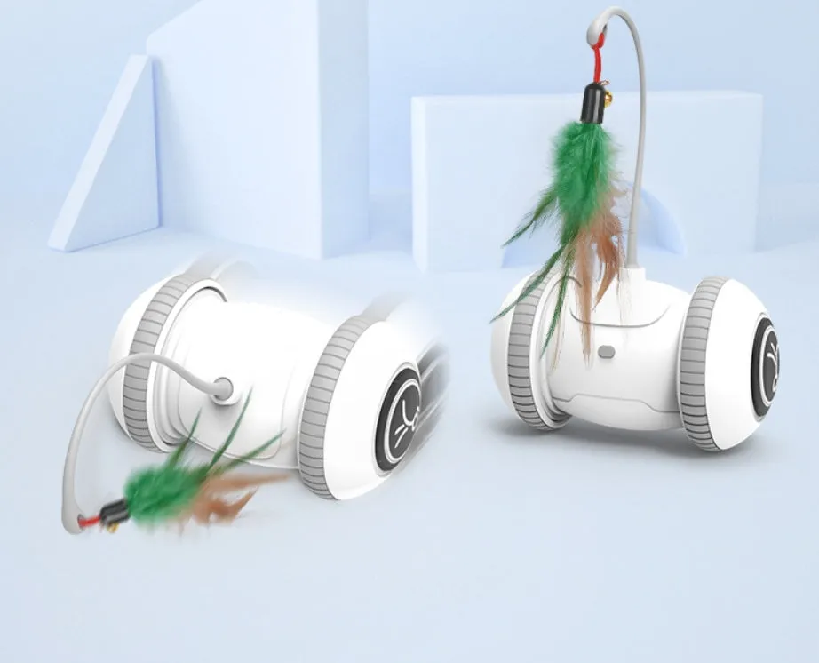 White and grey automatic interactive cat toy with interchangeable feather accessory on a floor, USB cable attached