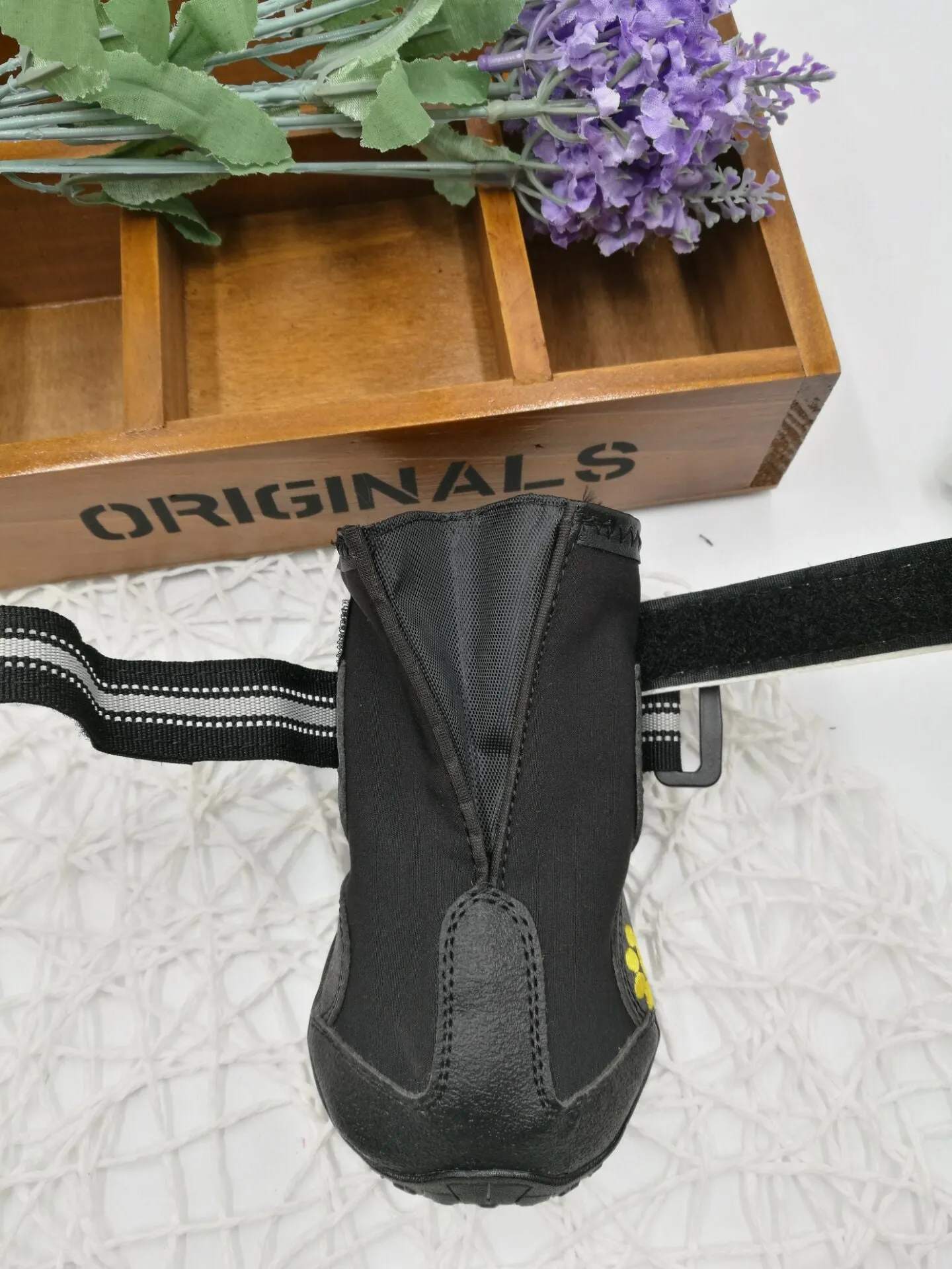 Black pet dog shoes with waterproof PVC sole and adjustable fuzzy belt on a light background