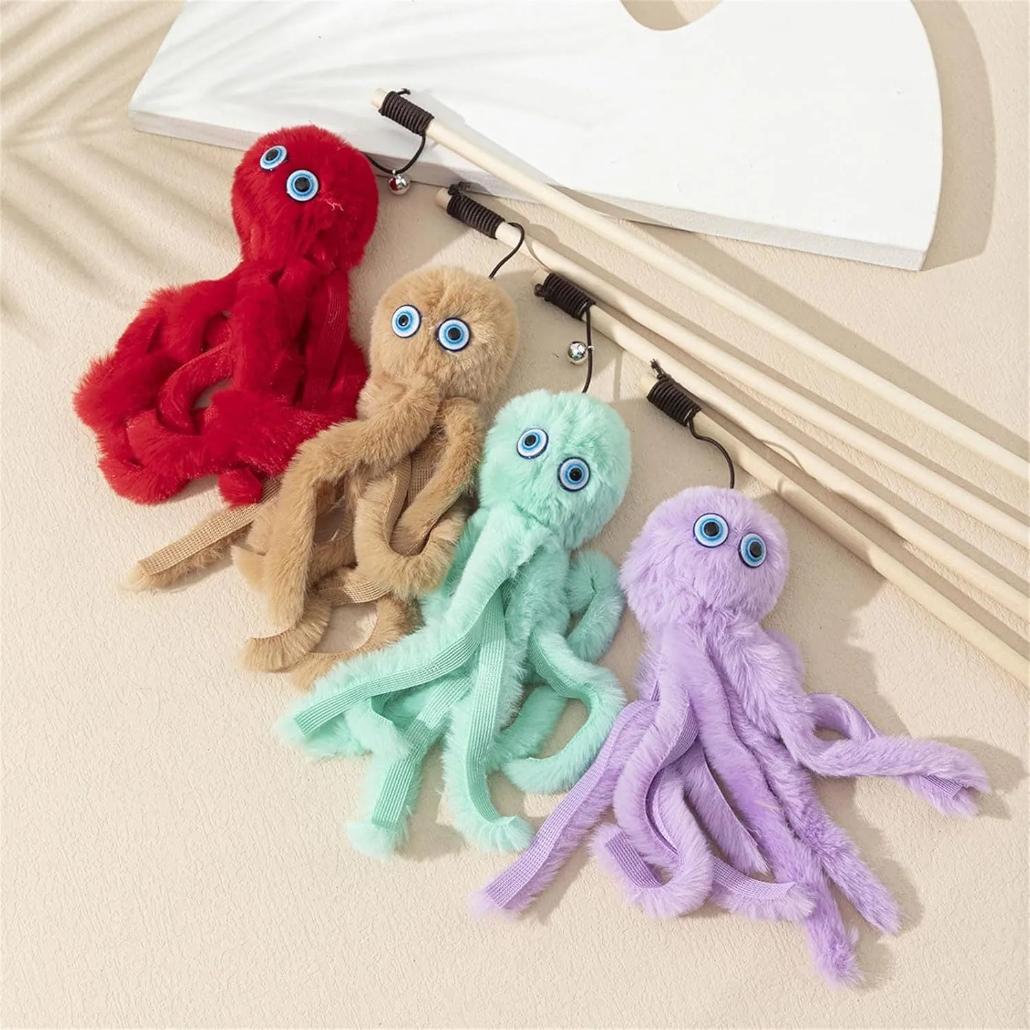 Octopus design cat toy with movable eyes on a long stick, shown in grey, pink, purple, or red.