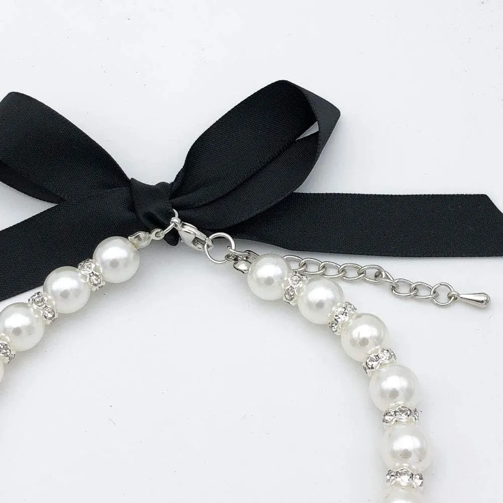 Small dog wearing adjustable pearl and rhinestone necklace with bow in blue colour