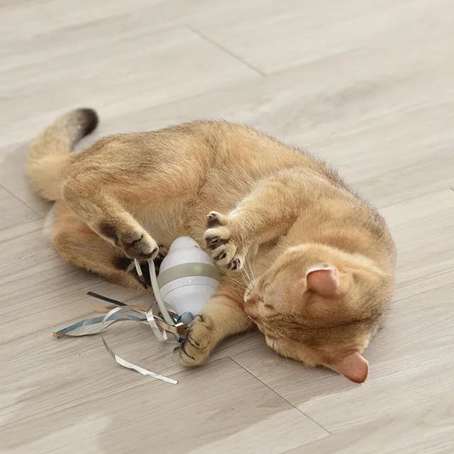 Gray 360 rolling mouse cat toy with feather tease on a floor