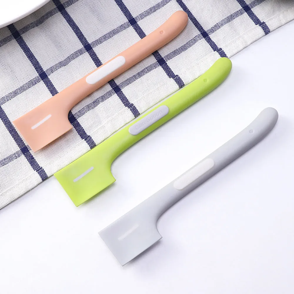 Green long-handled pet food spoon with angled head for scooping canned cat or dog food.