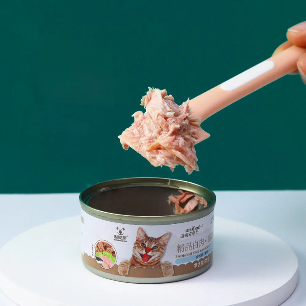 Green long-handled pet food spoon with angled head for scooping canned cat or dog food.
