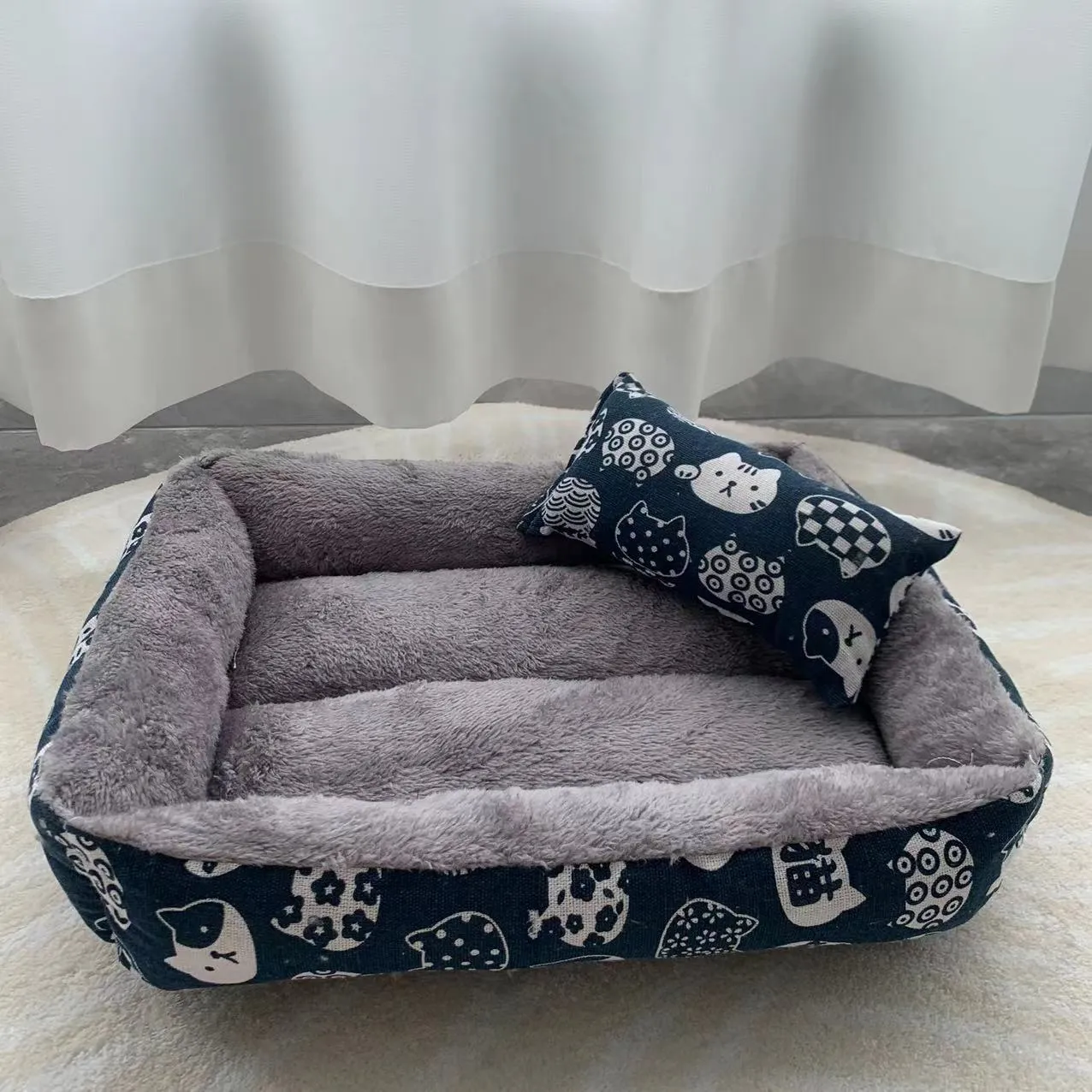 Moisture-proof linen dog bed in blue whale colour, rectangular shape with pillow, on floor.