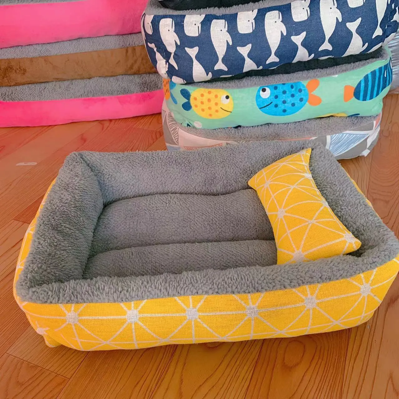 Moisture-proof linen dog bed in blue whale colour, rectangular shape with pillow, on floor.