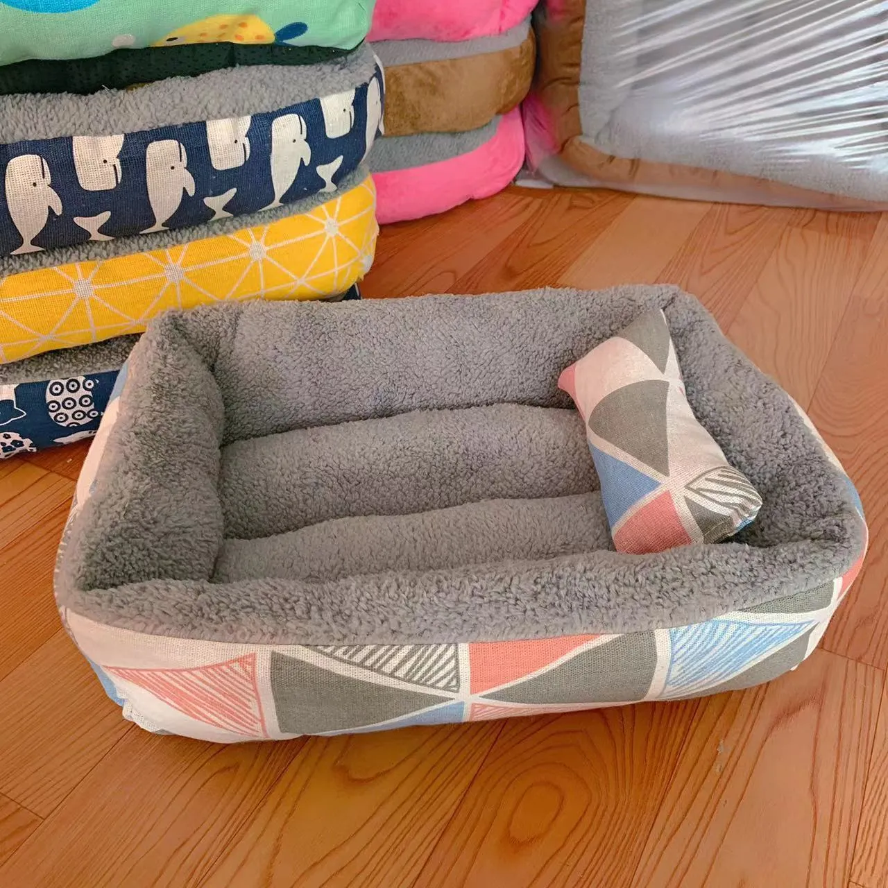 Moisture-proof linen dog bed in blue whale colour, rectangular shape with pillow, on floor.