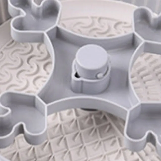 A rotating plastic pet feeding game board with an anti-choke pad and a detachable silicone licking mat in a windmill pattern.