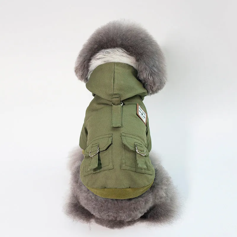 Small dog wearing a grey cotton and wool hooded coat standing on grass