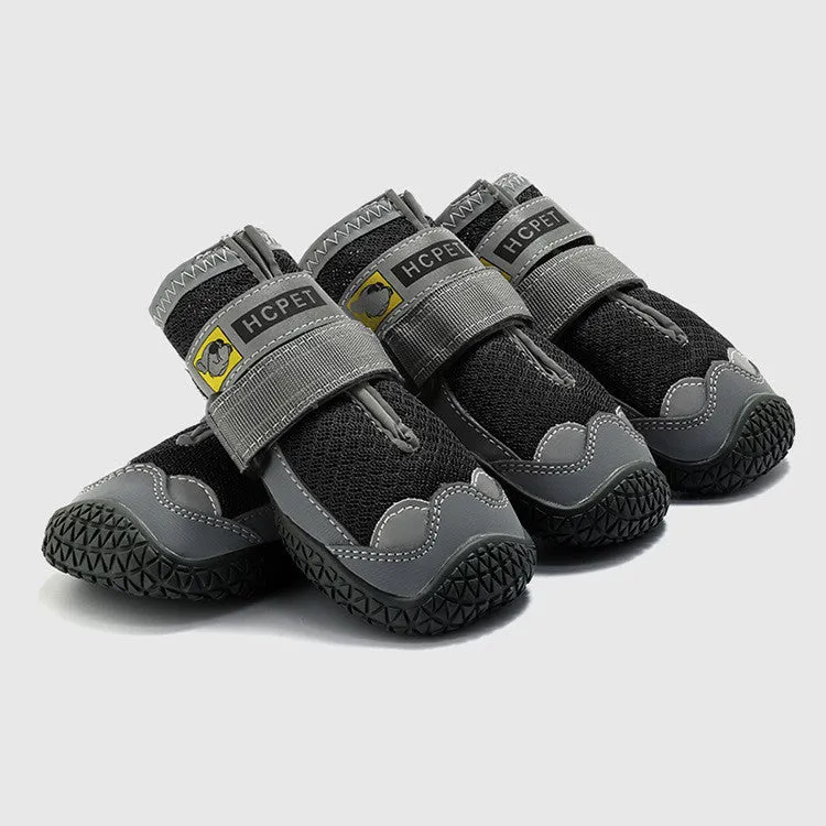 Pair of summer breathable pet dog shoes with non-slip rubber sole in gray black colour on outdoor surface