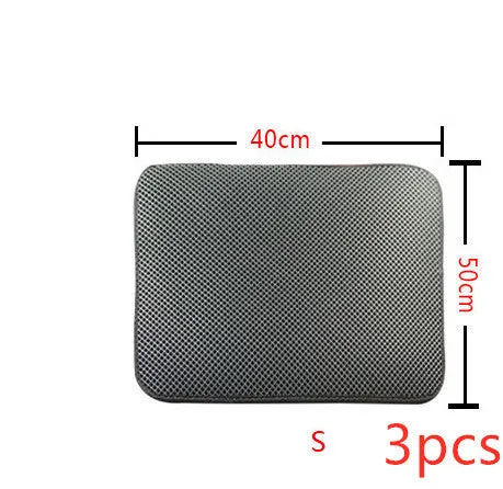 Double layer EVA cat litter mat in black with textured surface, placed under a litter box to trap debris