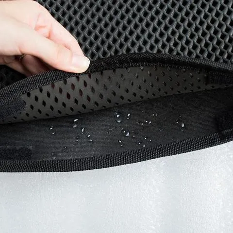 Double layer EVA cat litter mat in black with textured surface, placed under a litter box to trap debris