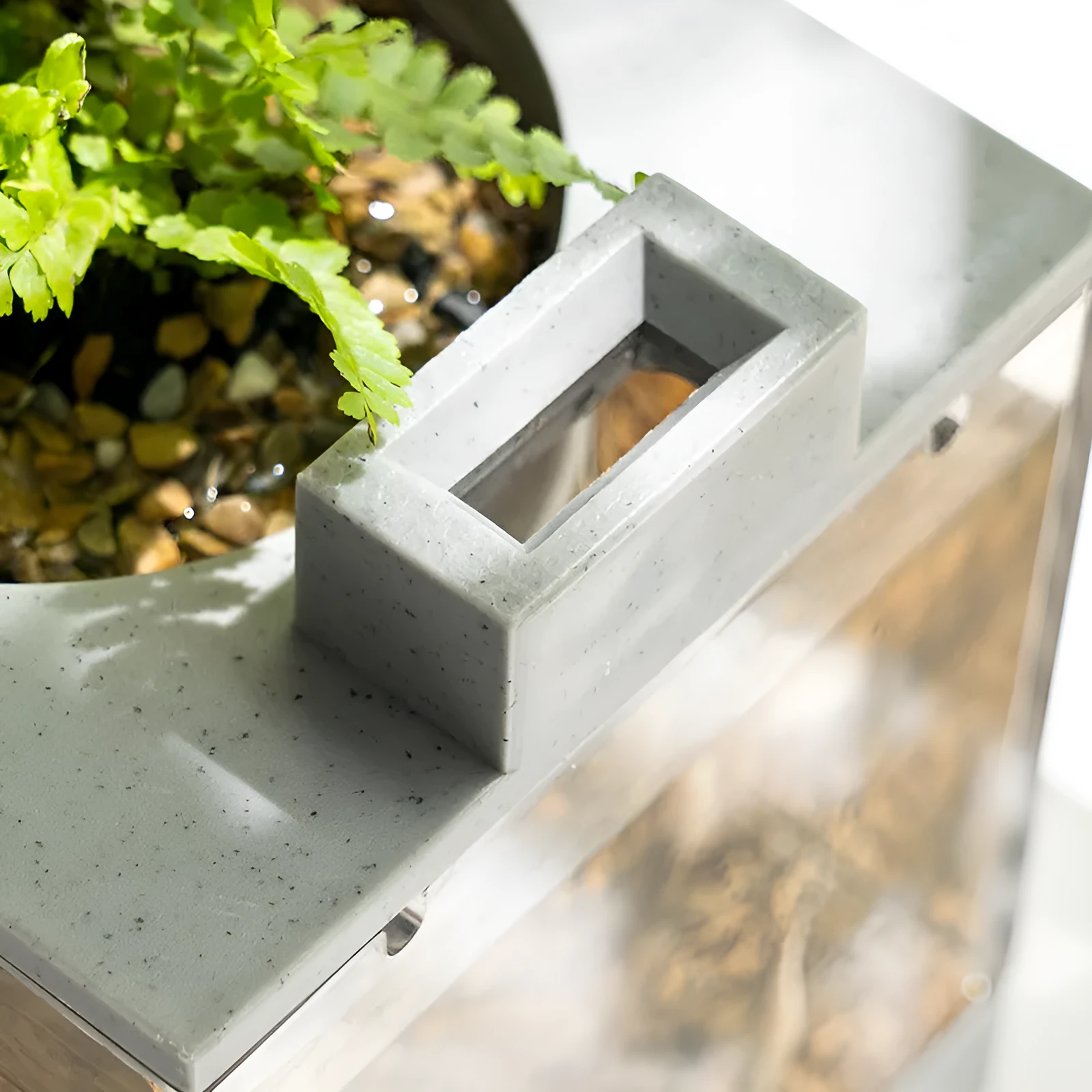 Small stone trough plastic fish tank with water pump and built-in light on a desk