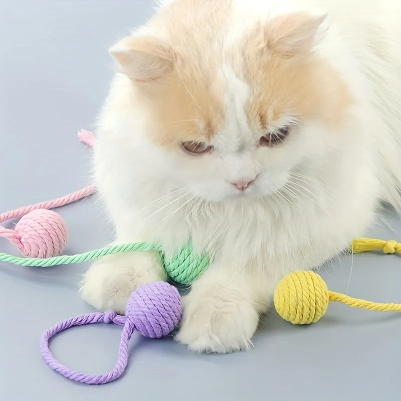 Colourful cat toy ball with attached rope and internal bell, shown in green, pink, purple, and yellow variants.