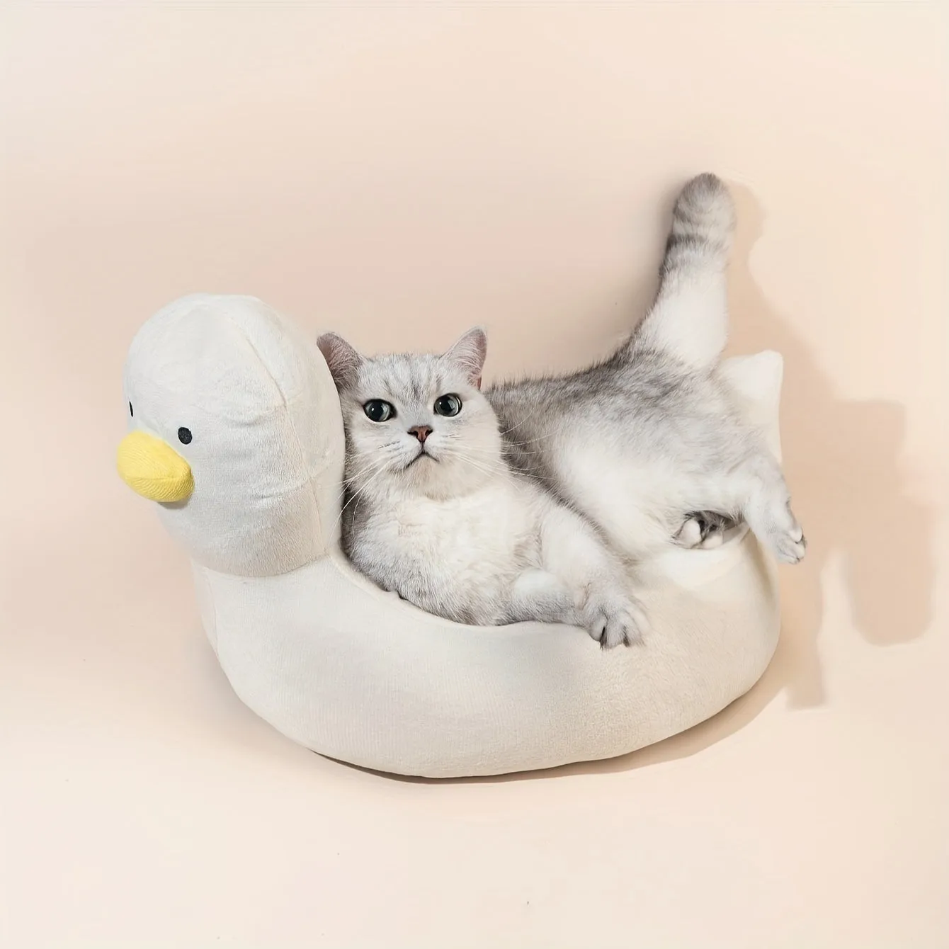 Blue duck-shaped fluffy pet bed for small dogs and cats on a wooden floor.