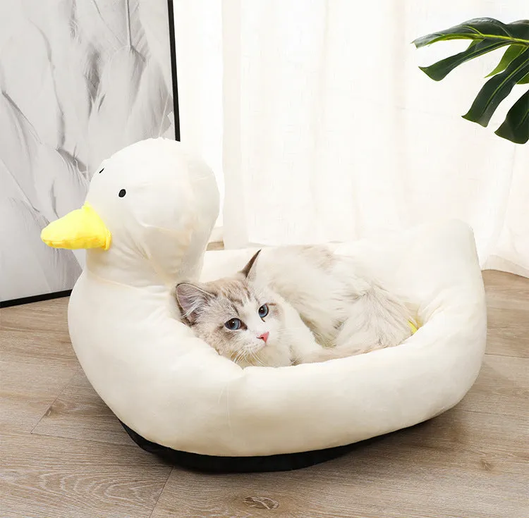 Blue duck-shaped fluffy pet bed for small dogs and cats on a wooden floor.