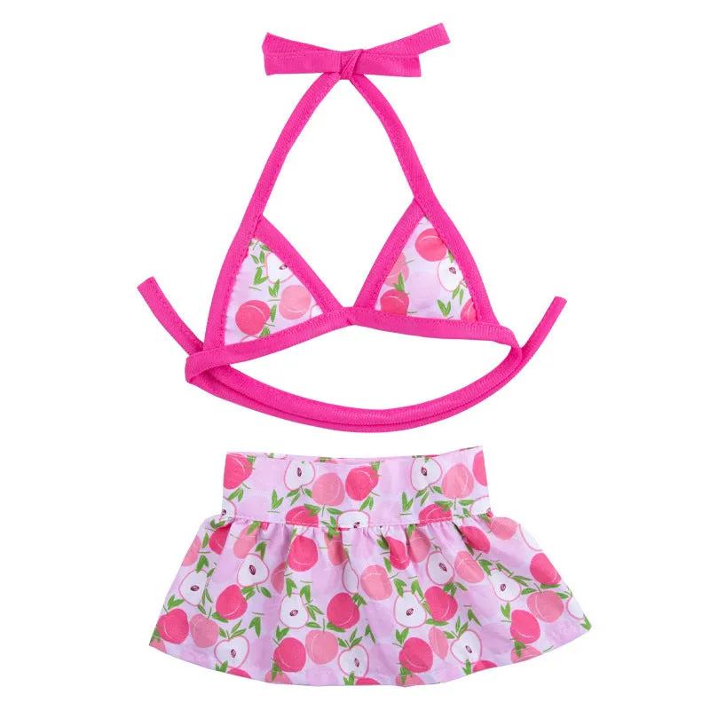 Dog wearing a pink dots polyester bikini suit lying on grass, summer pet clothing