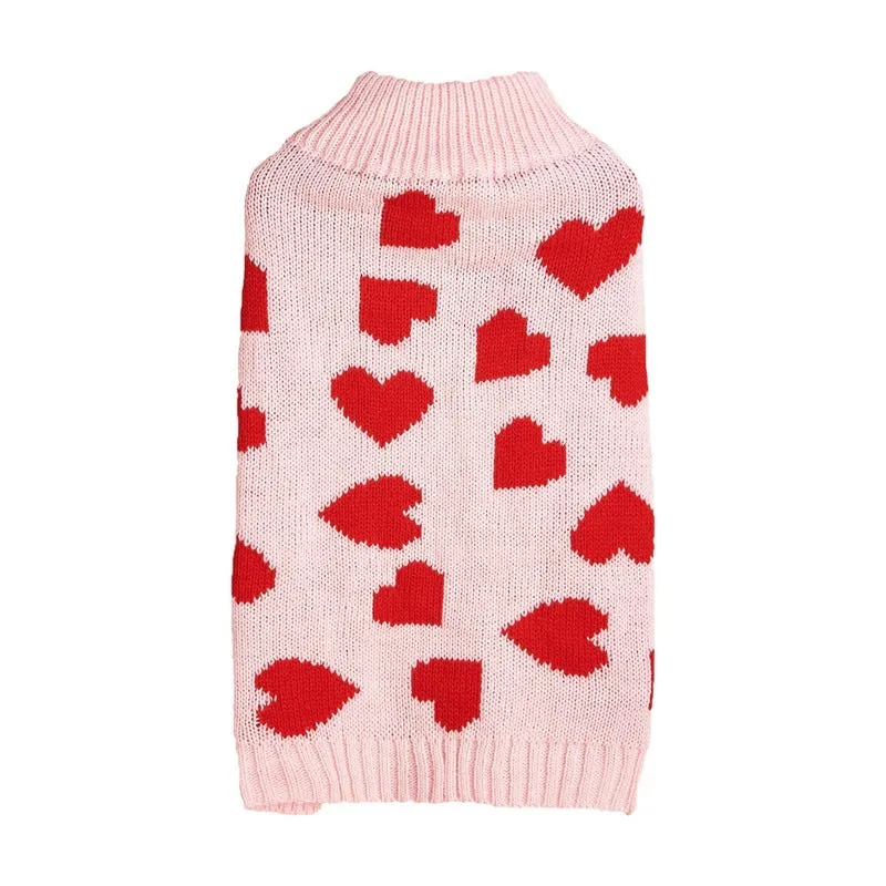 Dog wearing acrylic jumper with decorative heart or bow design in pink or red colours