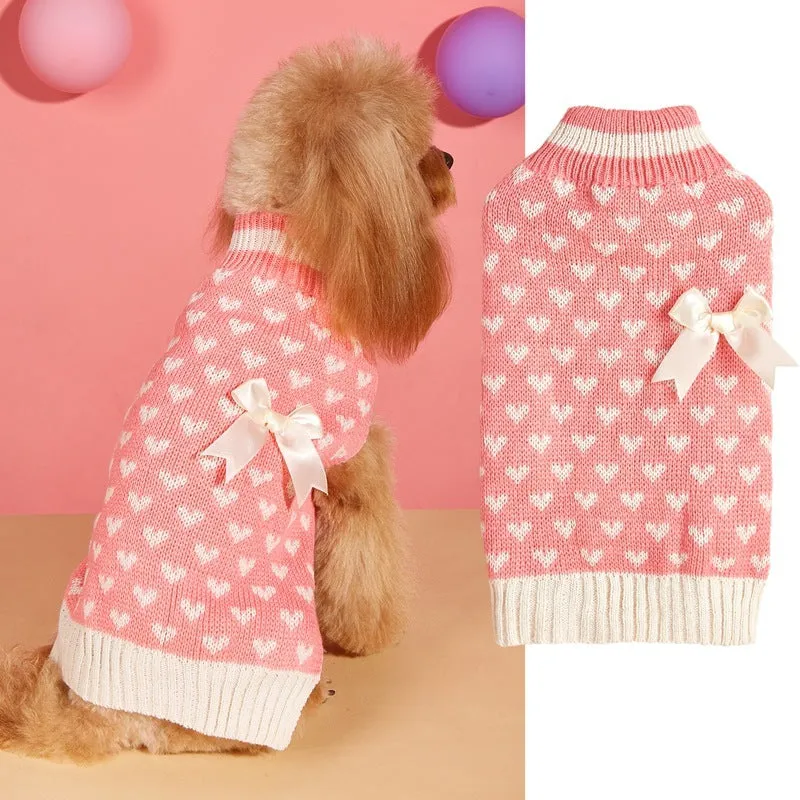Dog wearing acrylic jumper with decorative heart or bow design in pink or red colours